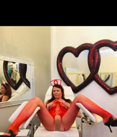 Eine Frau in roten Strümpfen sitzt auf einem Stuhl.