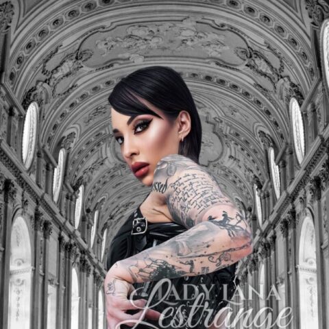 Eine Person in einem schwarzen Lederoutfit posiert in einem reich verzierten Korridor mit hohen Decken und Bögen. Über das Bild ist der Name „Lady Tana Lestrange“ gelegt.